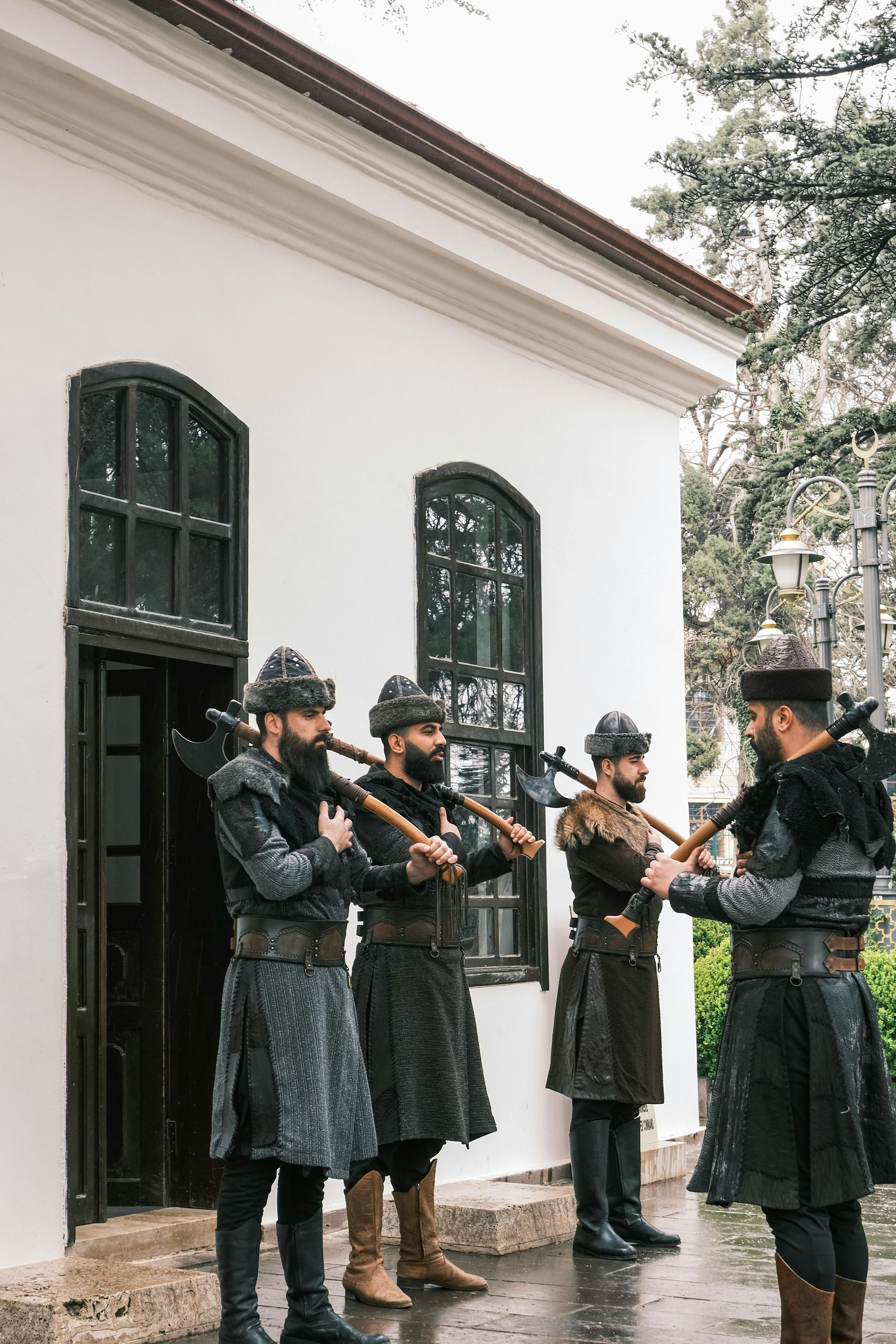 A group of men in medieval costumes are standing in front of a building.