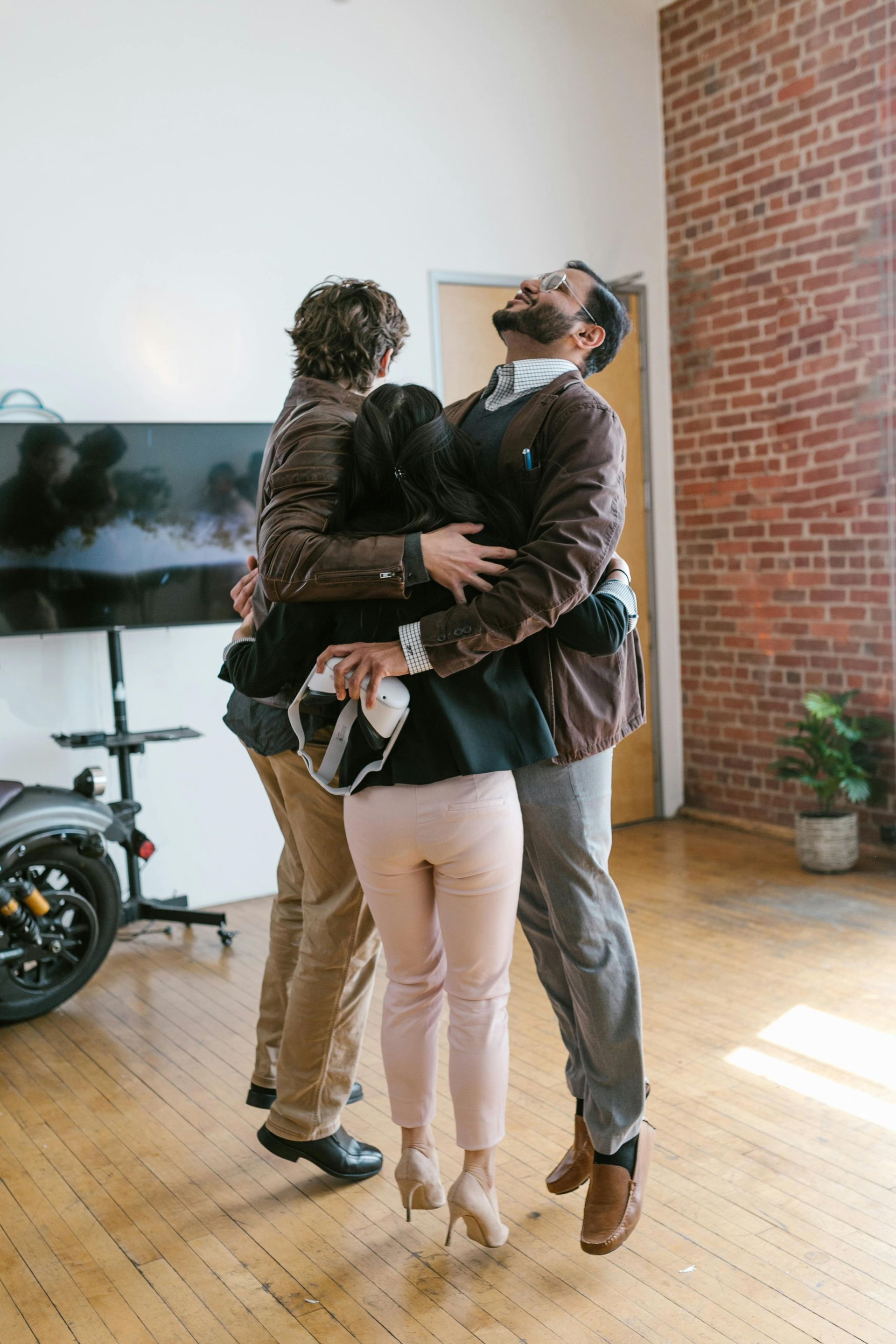A group of people are hugging each other in a room.