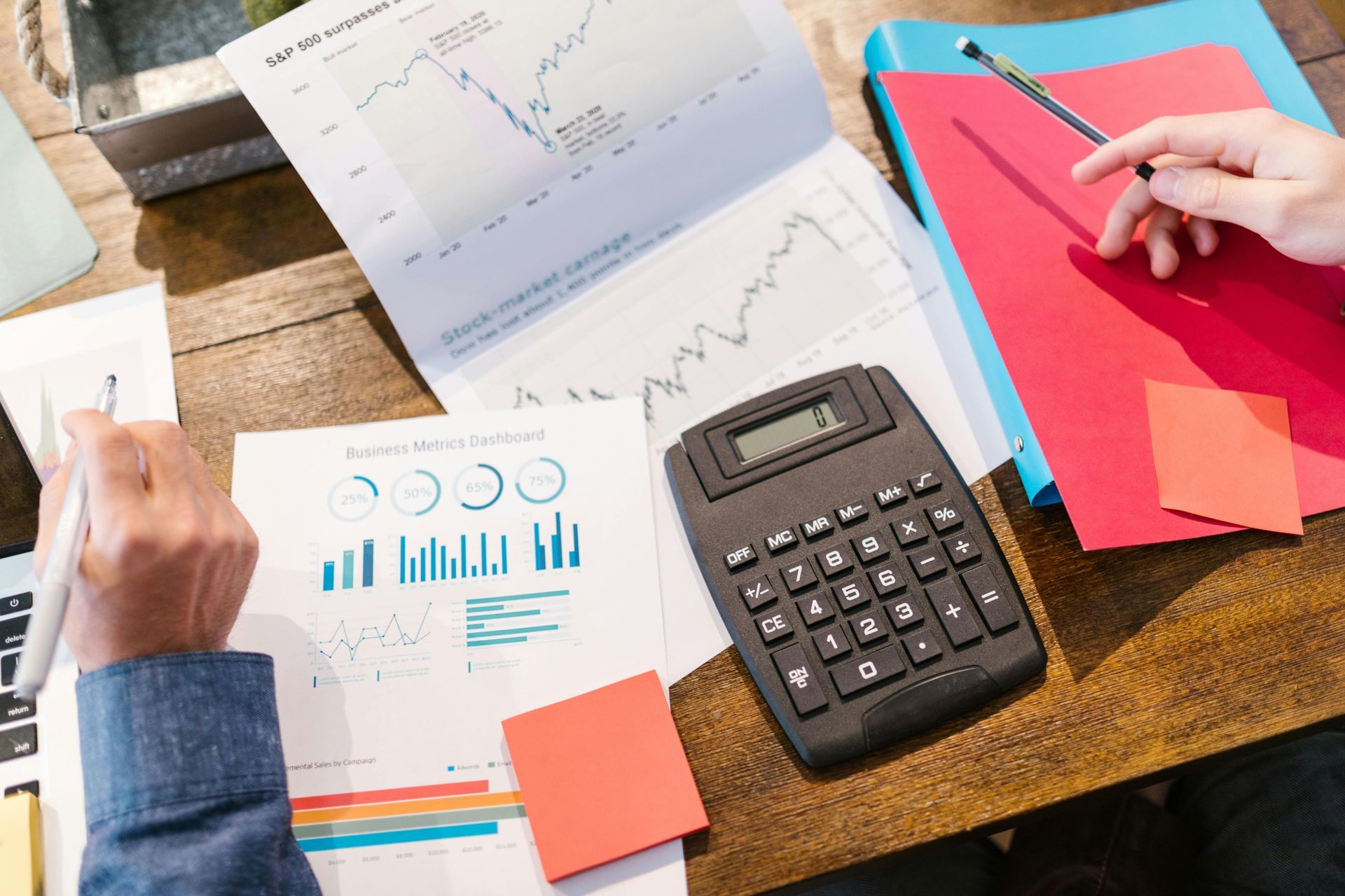 A person is sitting at a desk with a calculator and papers.