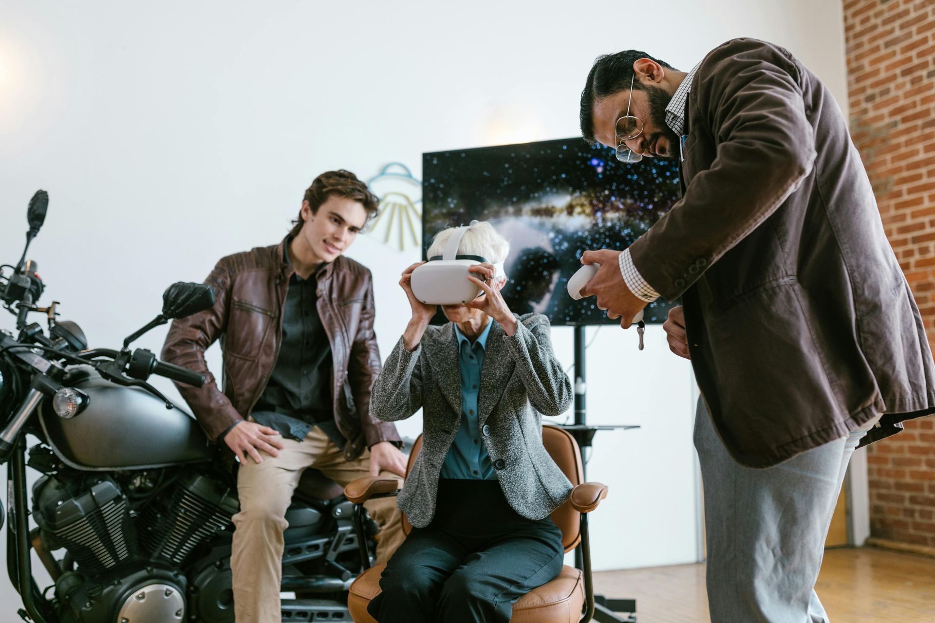 A group of people are using a virtual reality headset in front of a motorcycle.