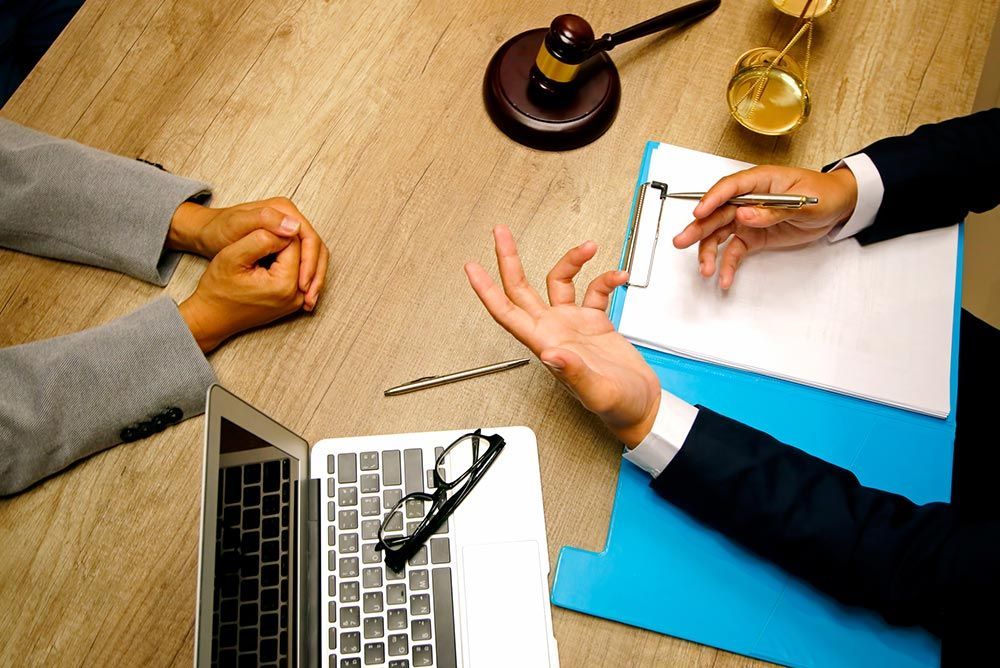 A Criminal Defense Lawyer in Marion, IL, consults with a client at a table.