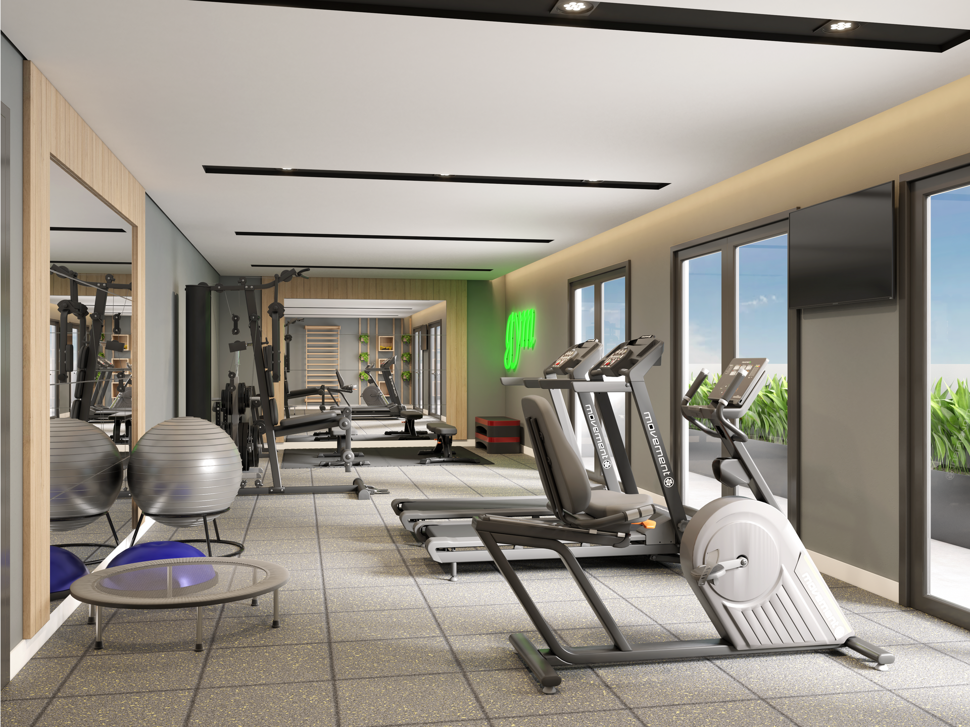 Interior de ginásio com equipamentos de ginástica: esteiras, pesos, espelhos e grandes janelas.