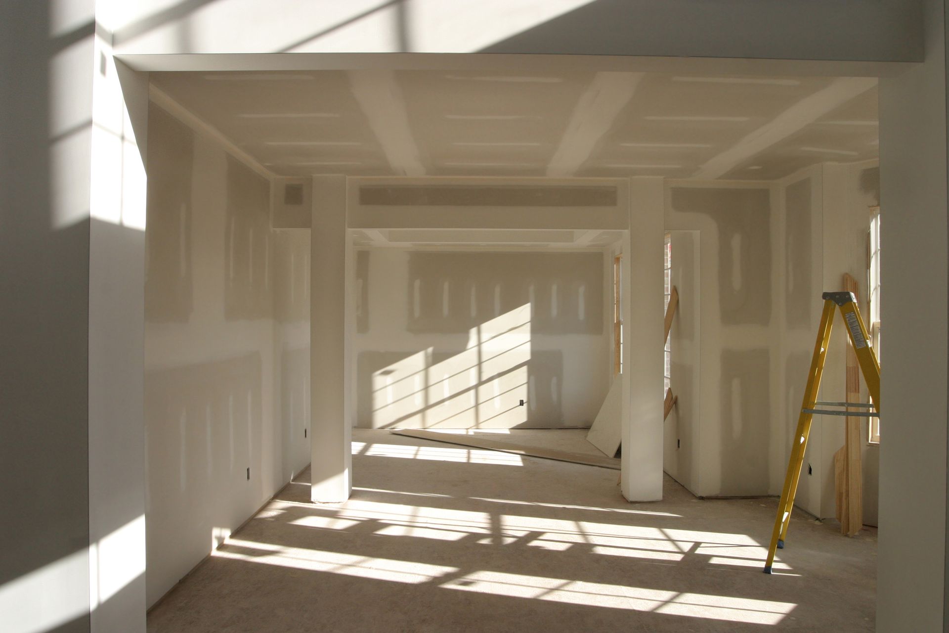 An empty room with a ladder on the floor