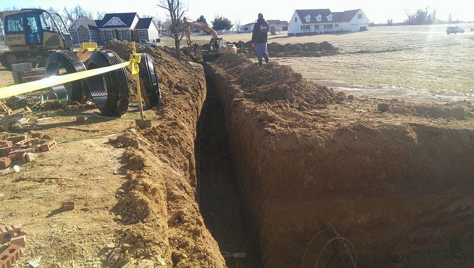 A man is standing in the dirt next to a tractor