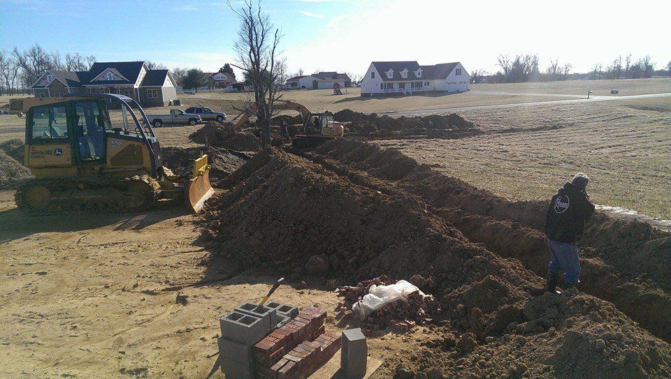 A bulldozer is digging a hole in a dirt field.