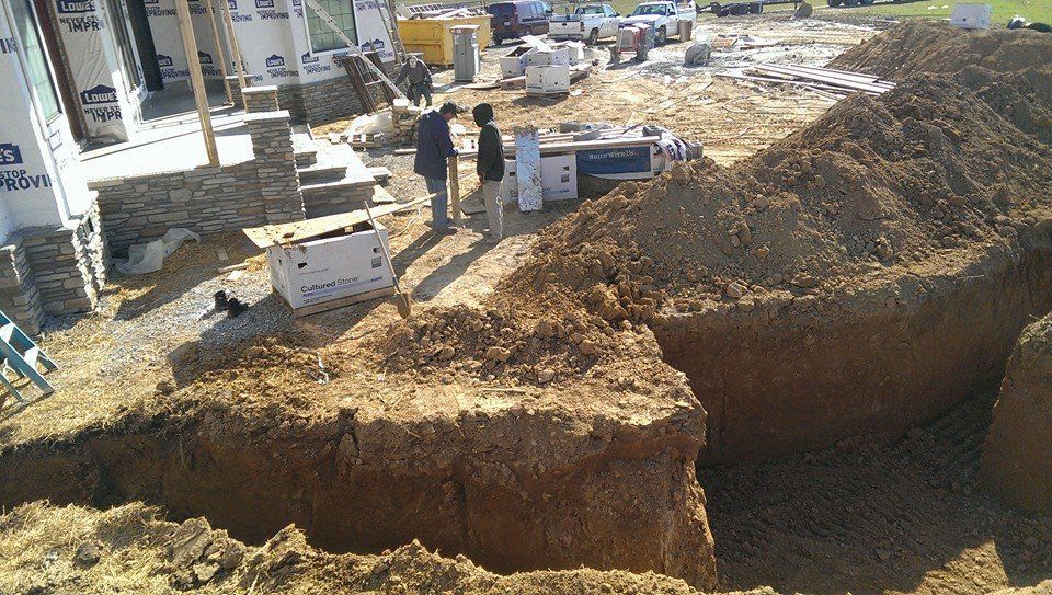A group of people are standing around a large pile of dirt