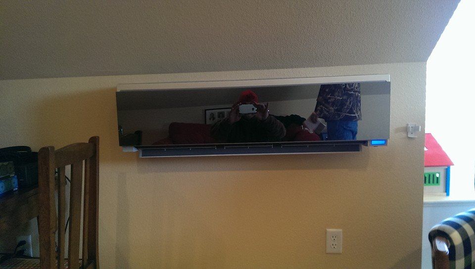 A large mirror is hanging on a wall in a living room.