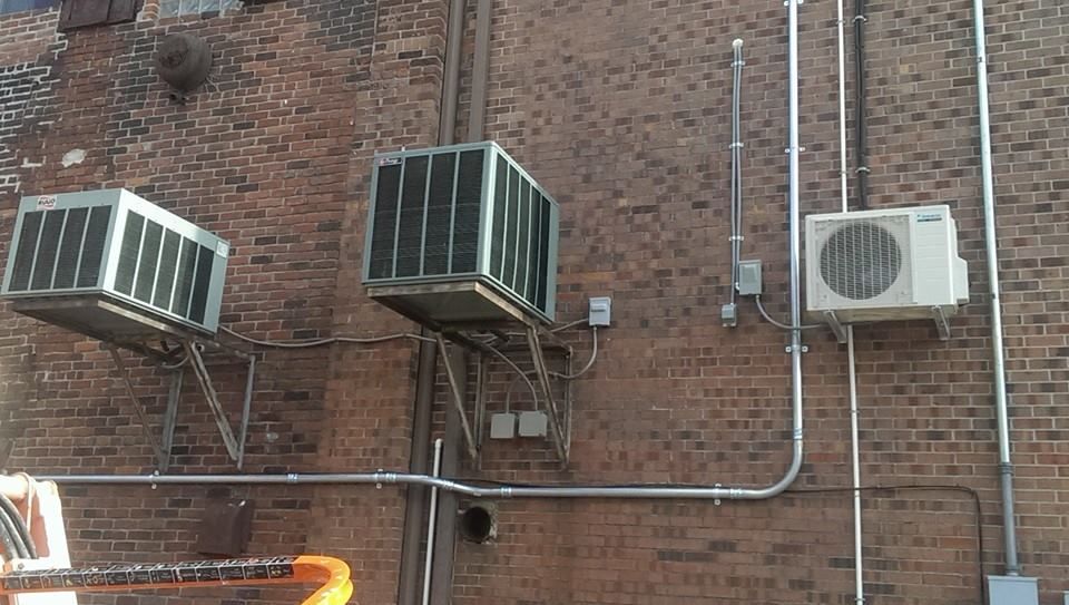 A brick wall with a bunch of air conditioners on it