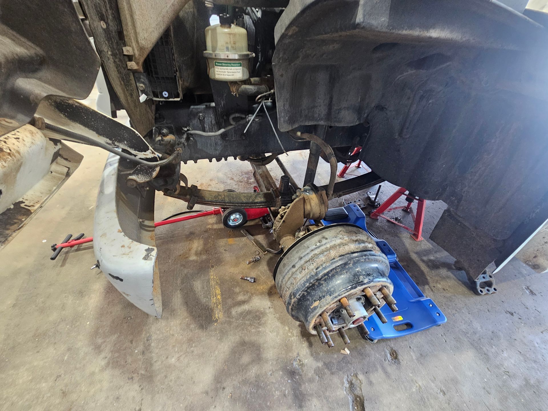 Broken Rear Axle and Wheel Assembly in a Garage — Cap Coast Maintenance In Alton Downs, QLD