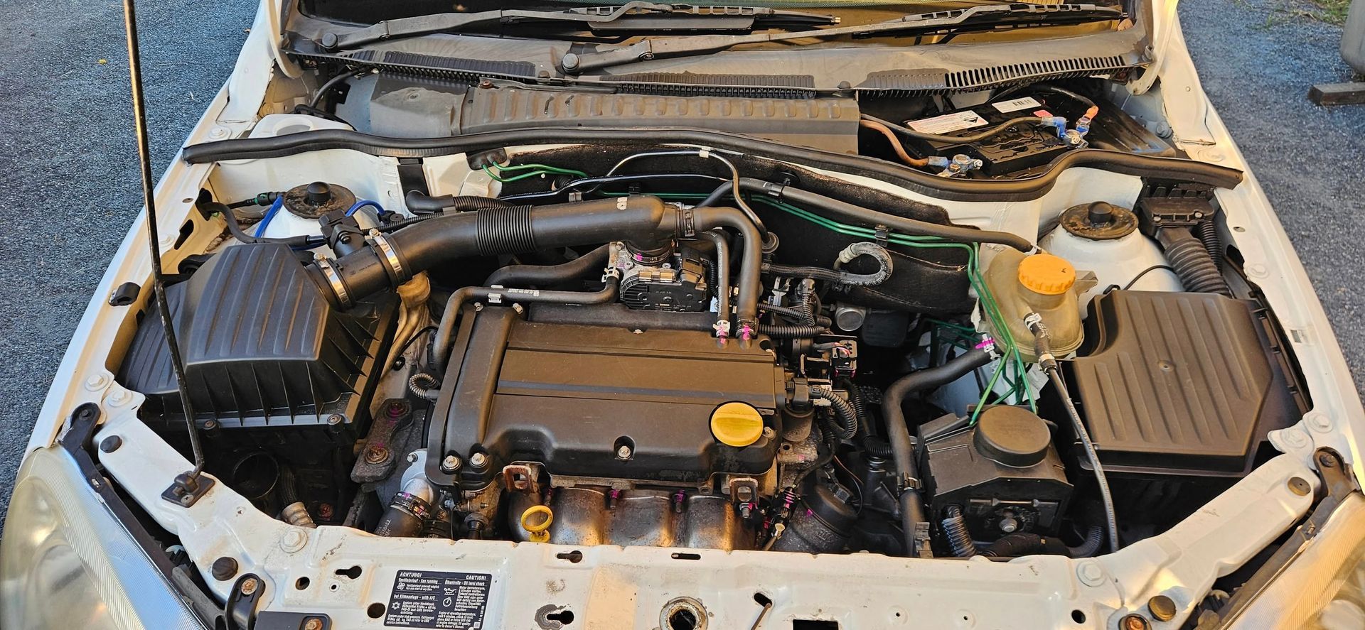 Car engine compartment with black engine and various parts.— Cap Coast Maintenance In Alton Downs, QLD
