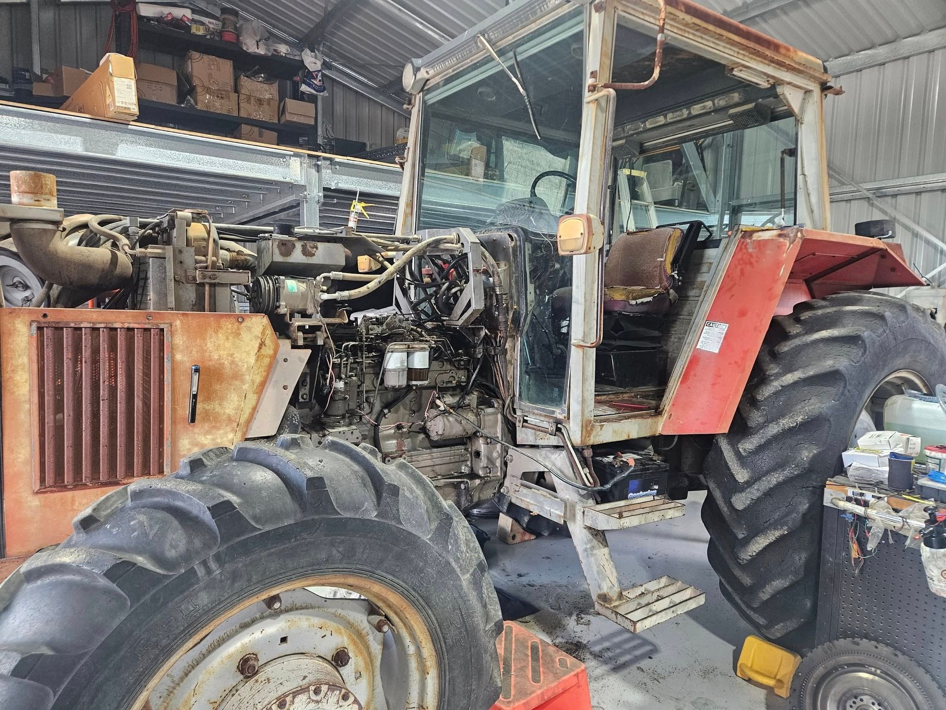Partially Disassembled Rusty Orange Tractor in a Workshop — Cap Coast Maintenance In Alton Downs, QLD