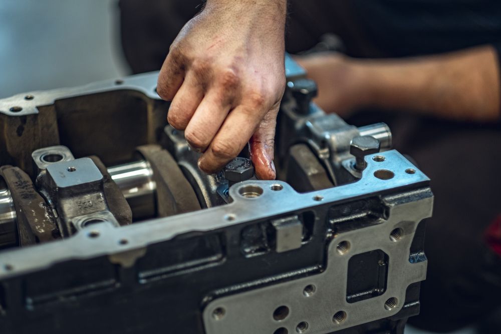 Mechanic's Hand Working on an Engine Block — Cap Coast Maintenance In Alton Downs, QLD
