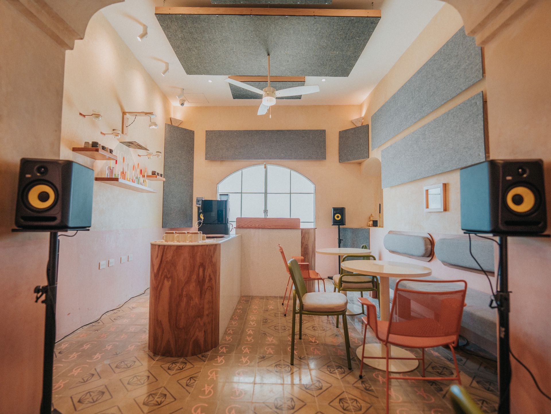 Una habitación con mesas y sillas y altavoces en la pared.