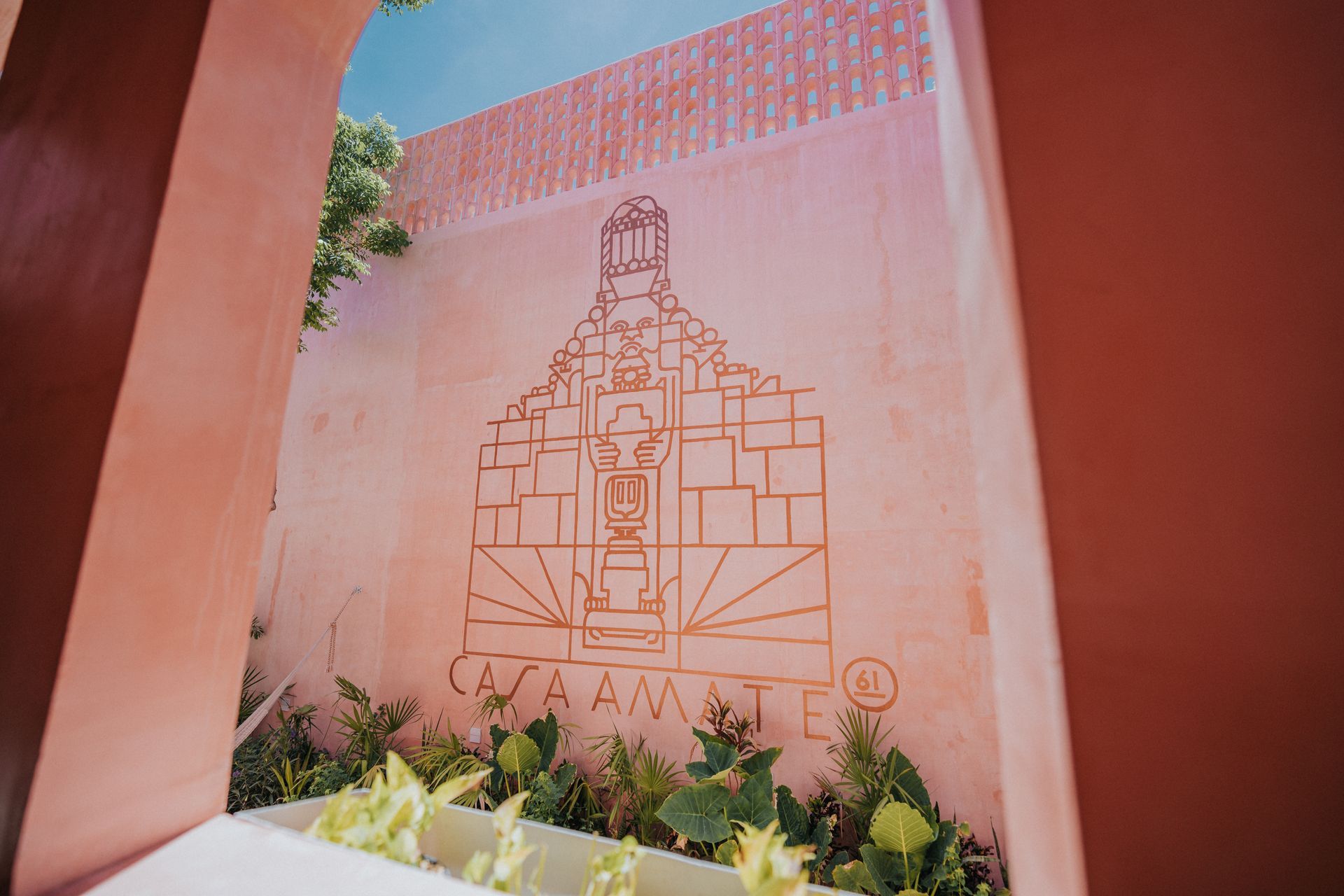 Una pared rosa con un dibujo de un edificio en ella.