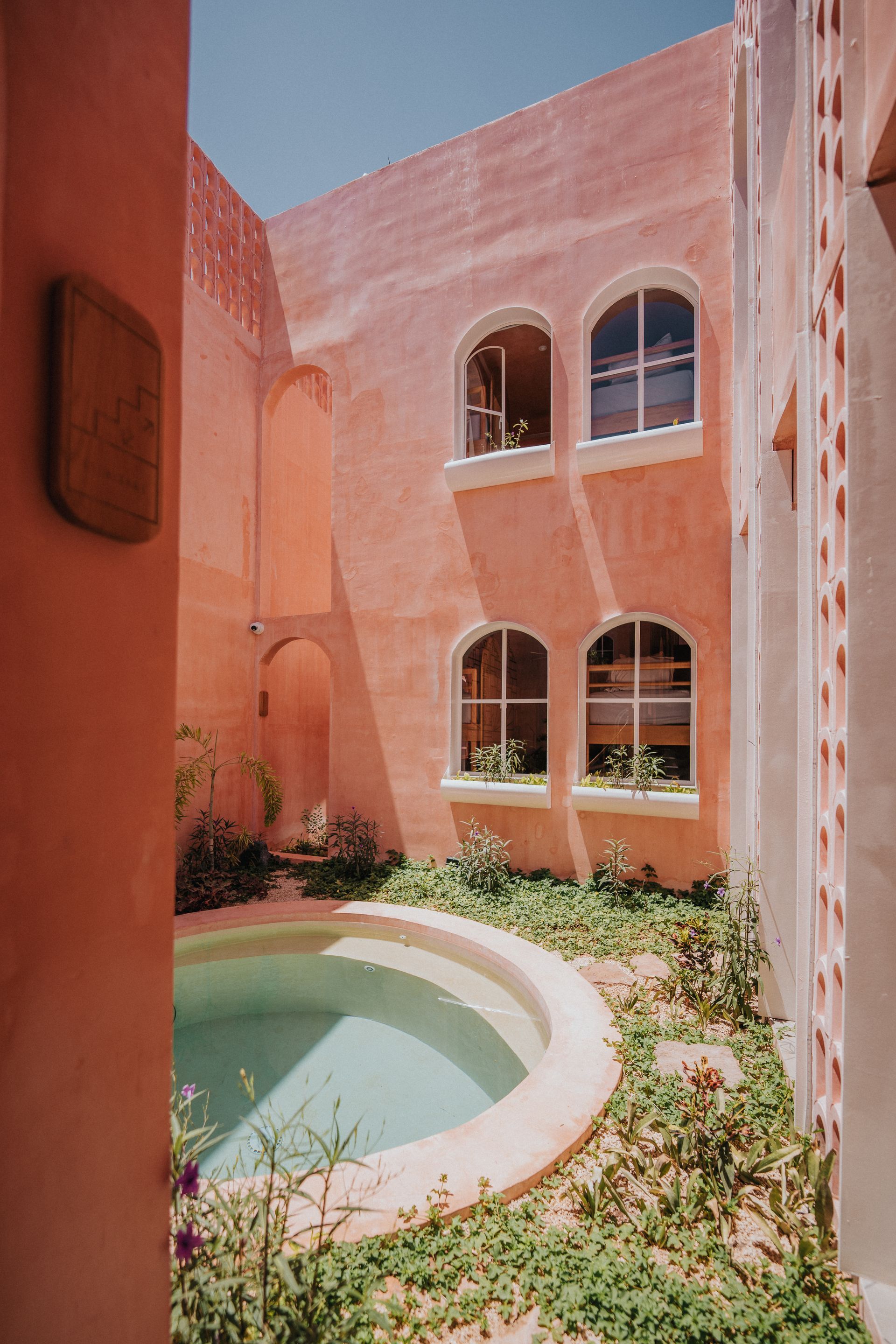 Un edificio rosa con una piscina en el medio.