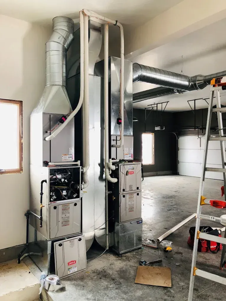 Woman at desk with hands clasped, listening to a man in a suit reviewing documents. Office setting.