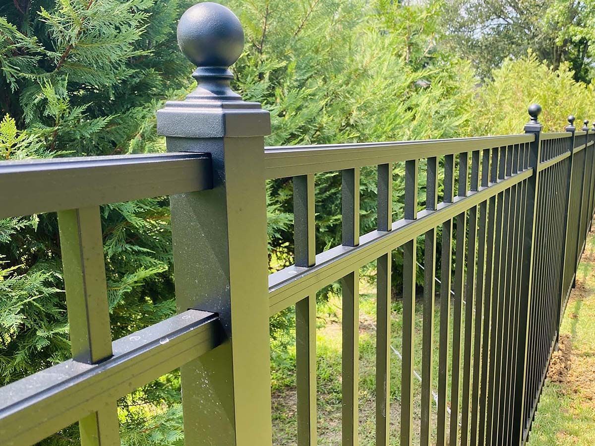 A close up of a fence with trees in the background.