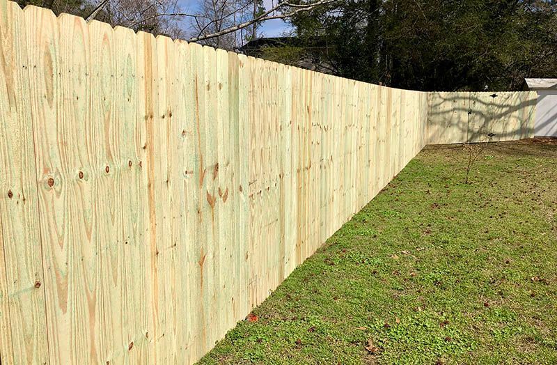 A wooden fence is sitting in the middle of a grassy yard.