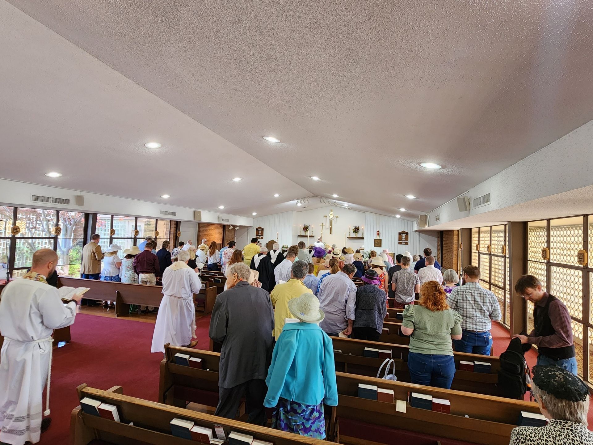 People stand inside a church during a service.