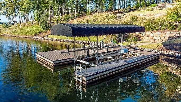 A dock on a lake with a black canopy