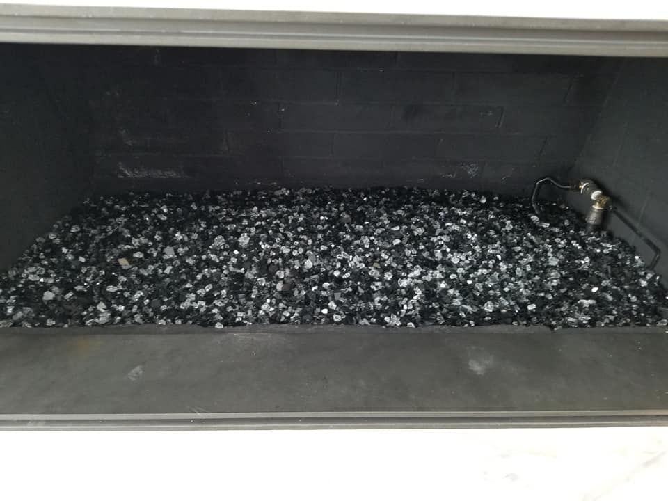 Black crushed glass in a fireplace.