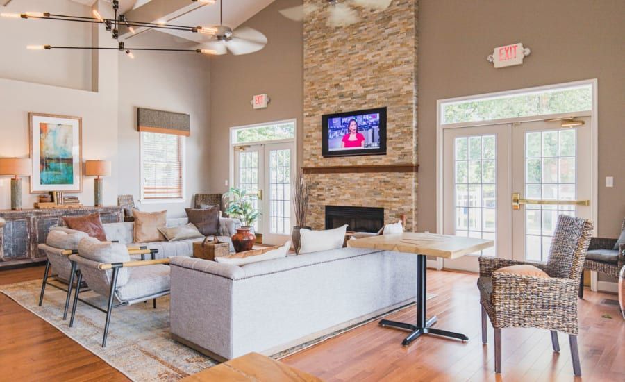 A living room with a couch , chairs , tables and a fireplace at Westgate Apartments & Townhomes in Manassas, VA.