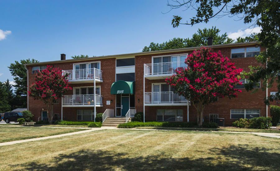 A large brick apartment building with a green awning at Westgate Apartments & Townhomes in Manassas, VA.