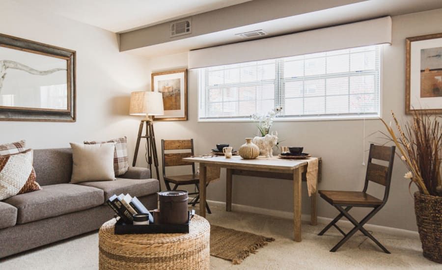 A living room with a couch , table and chairs at Westgate Apartments & Townhomes in Manassas, VA.