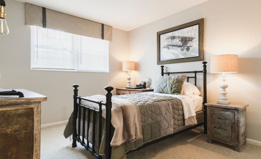 A bedroom with a bed , nightstand , dresser and window at Westgate Apartments & Townhomes in Manassas, VA.