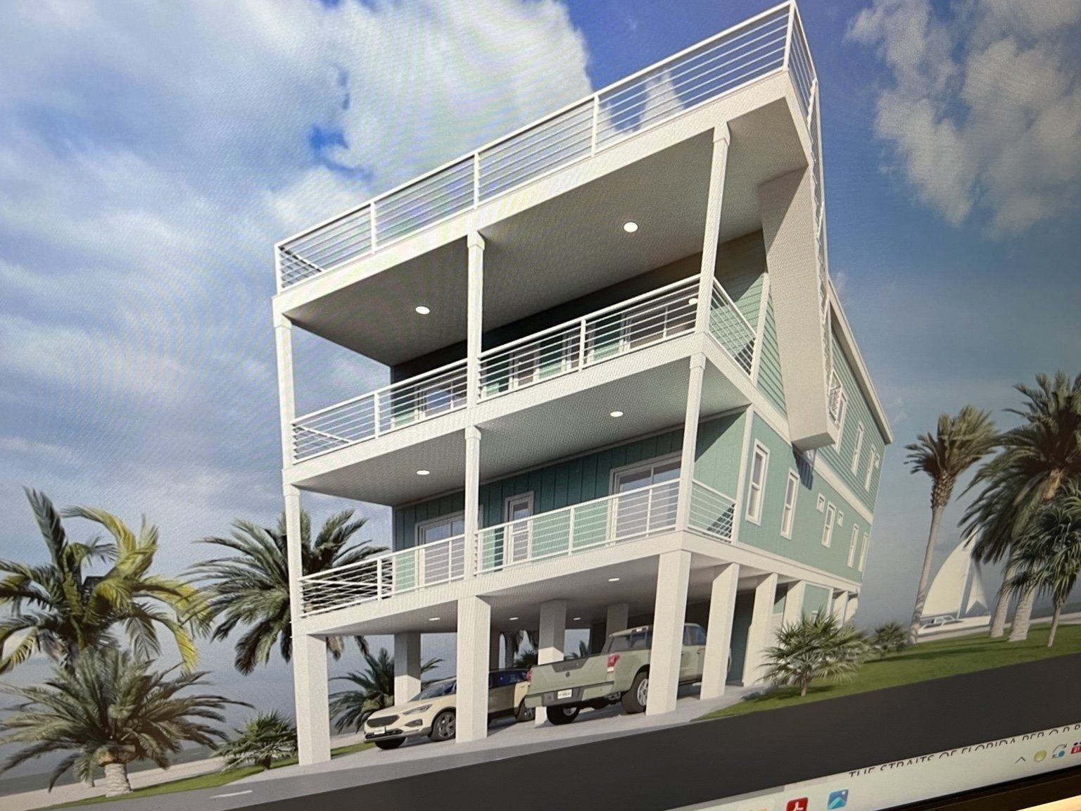 Modern white beachfront house with balconies, palm trees, and cars on the ground level