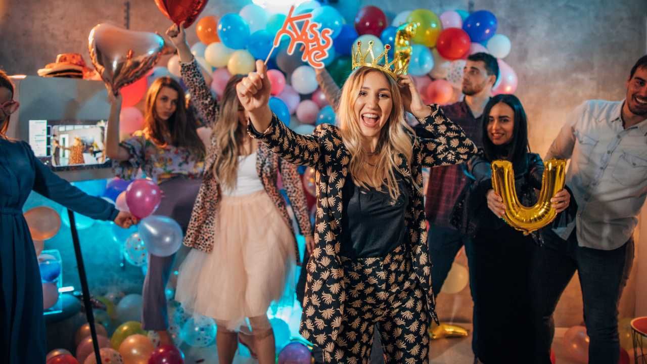 A lively party scene featuring cheerful individuals surrounded by vibrant balloons.