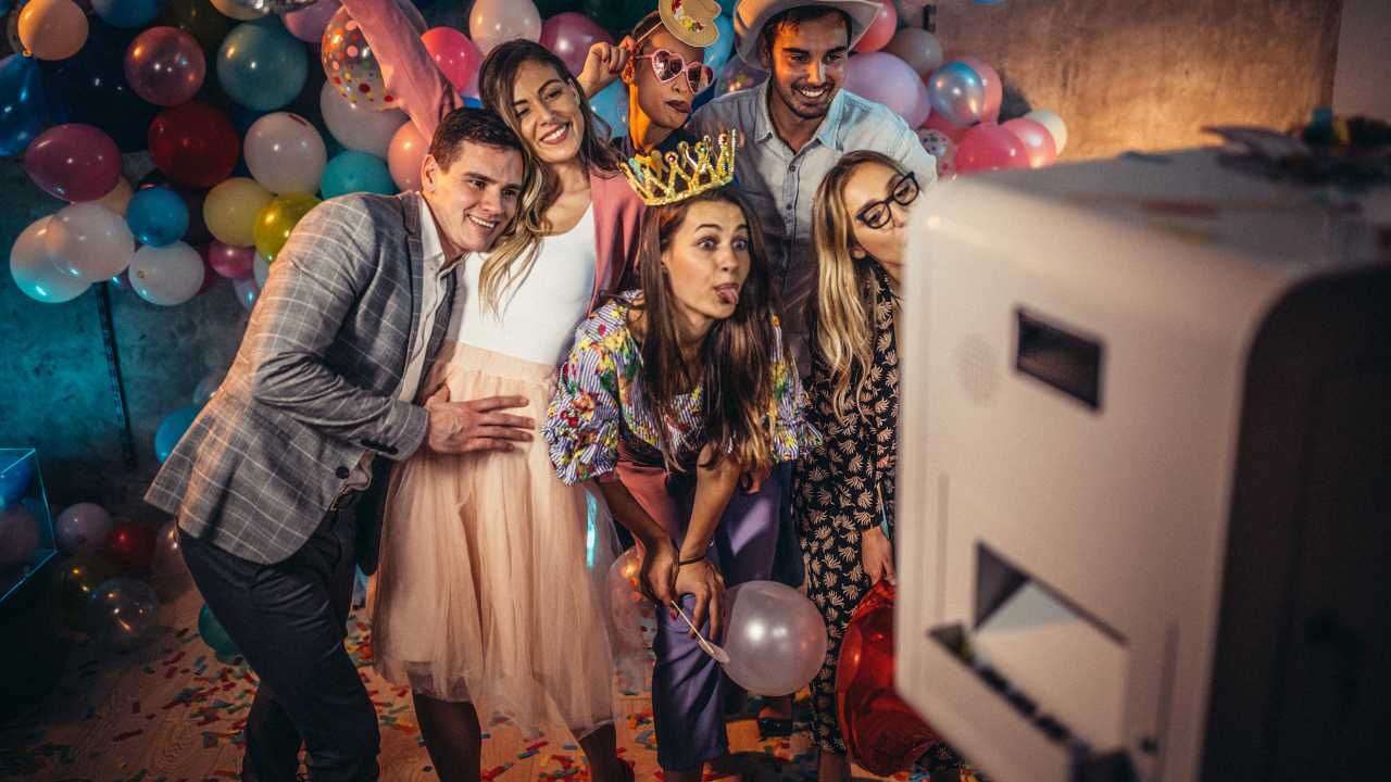 A group of people are posing for a picture in a photo booth at a party.