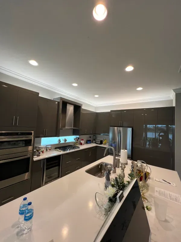 Modern kitchen with grey cabinets, white countertops, and stainless steel appliances.