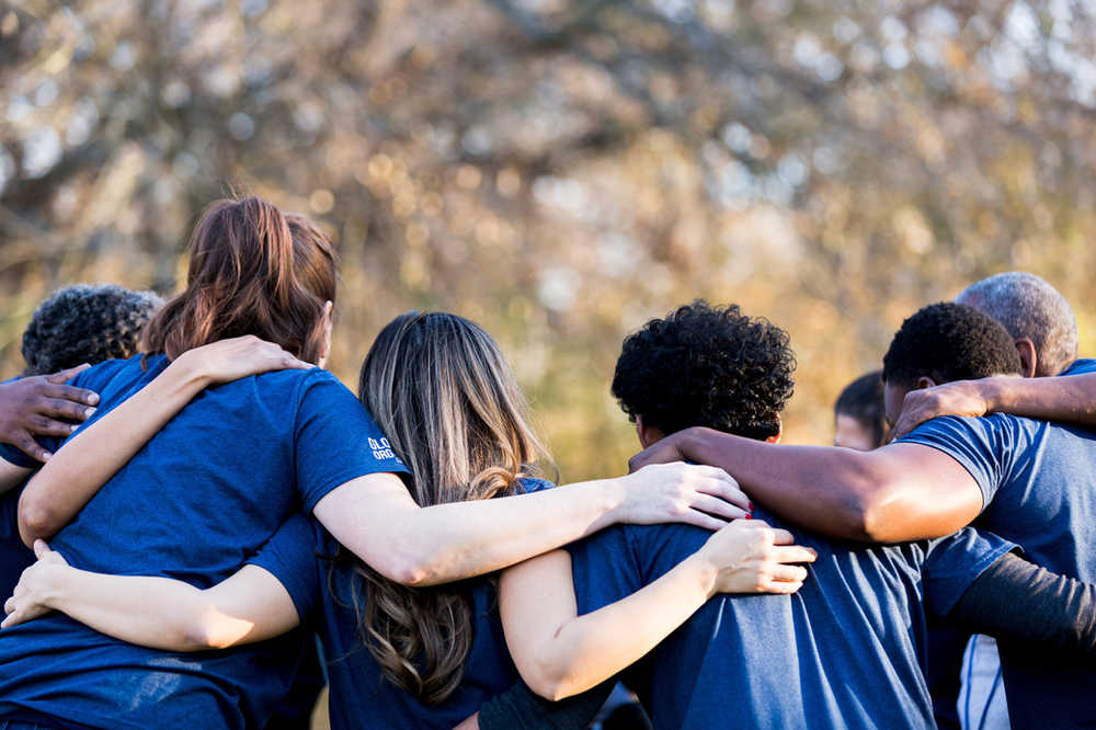 A group of people are hugging each other in a huddle.