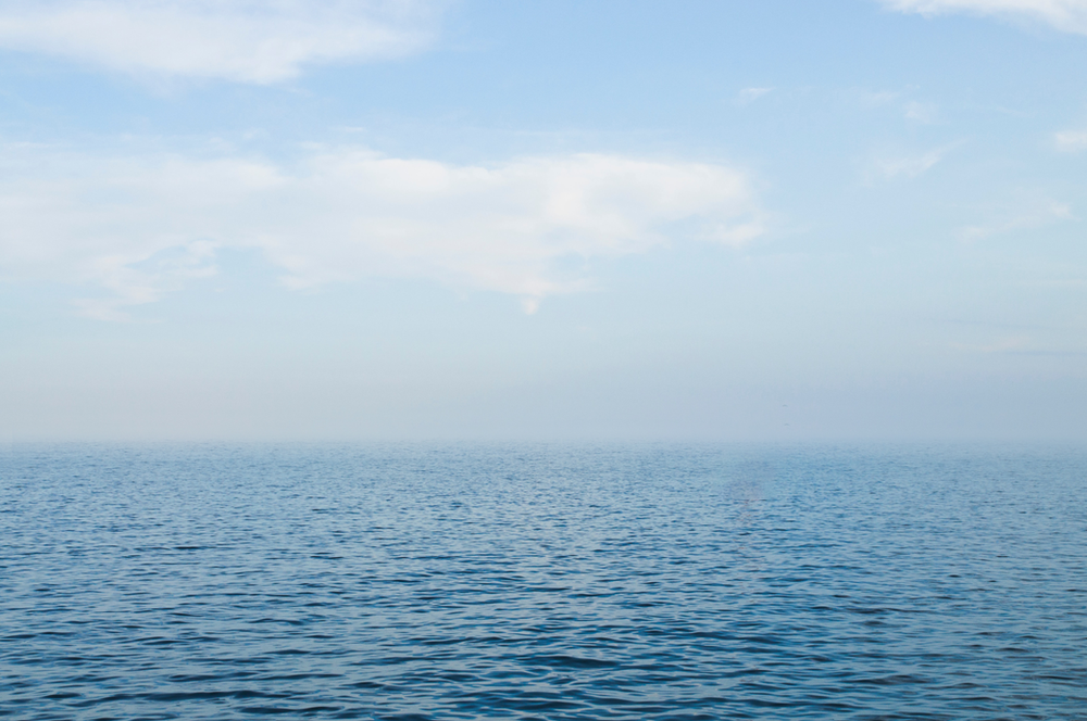 A large body of water with a blue sky in the background.