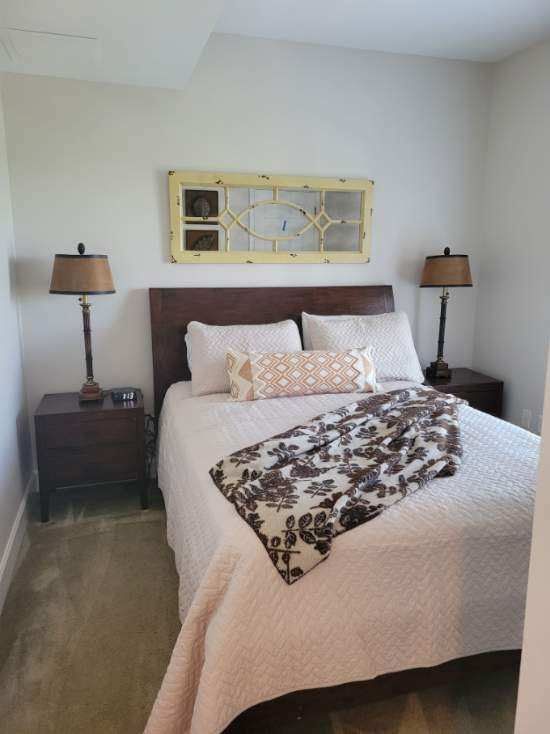 Bedroom with a bed, nightstands, lamps, and a decorative window pane.