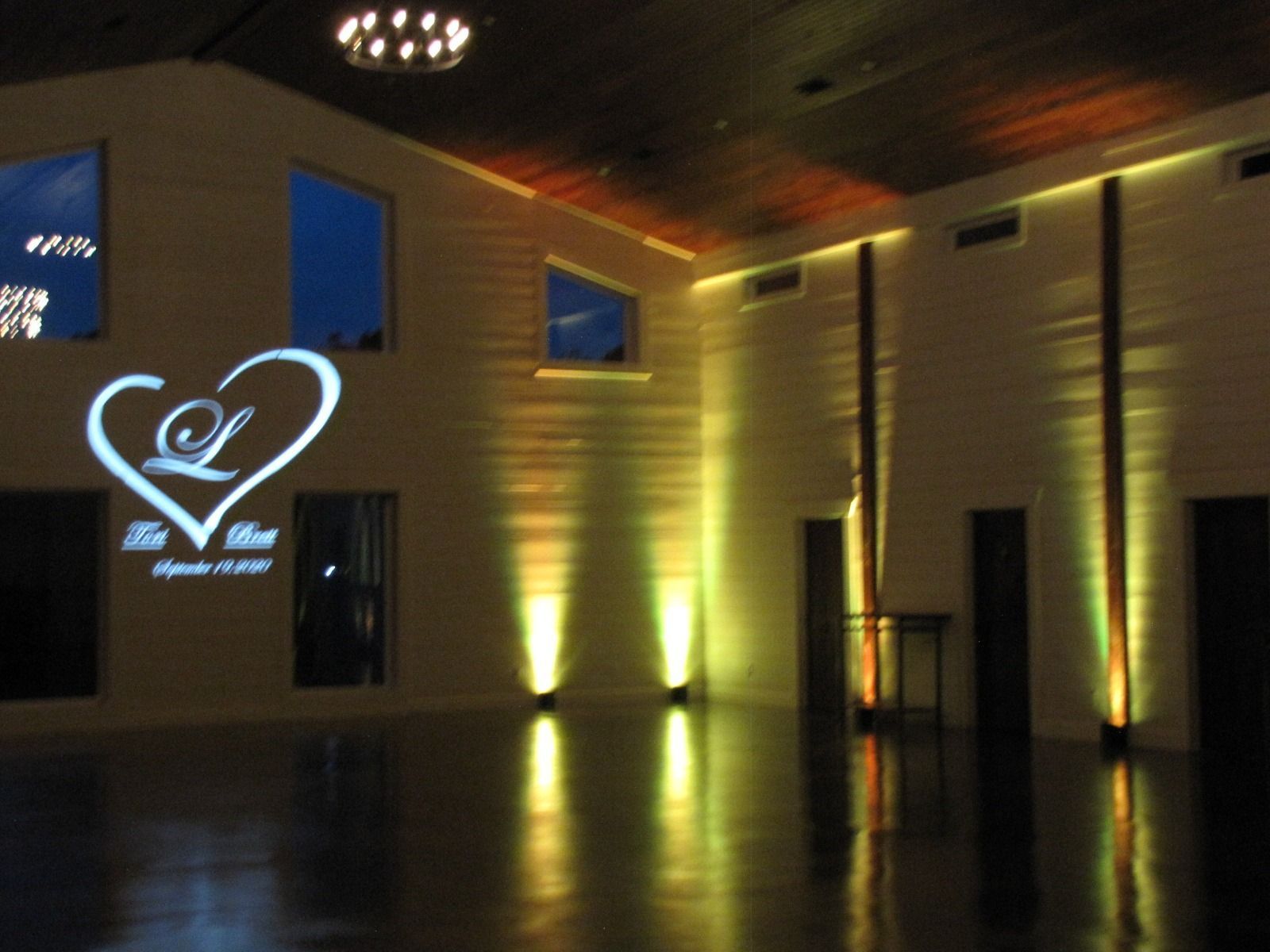 Dimly lit lobby with gold uplighting and a glowing heart-shaped logo on the wall