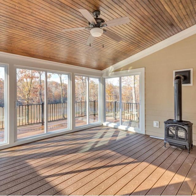 A living room with lots of windows and a ceiling fan