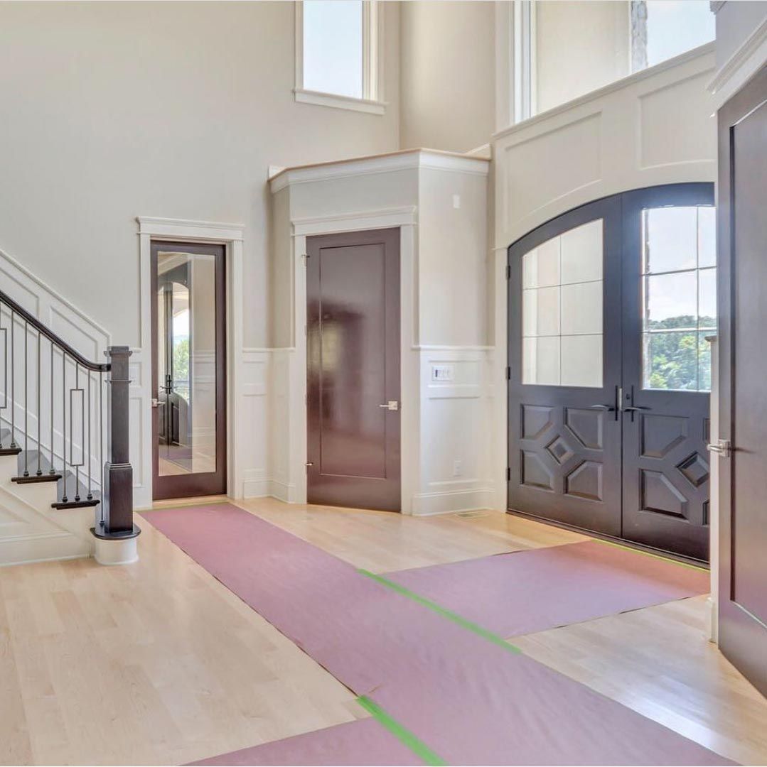 A hallway with a staircase and a door