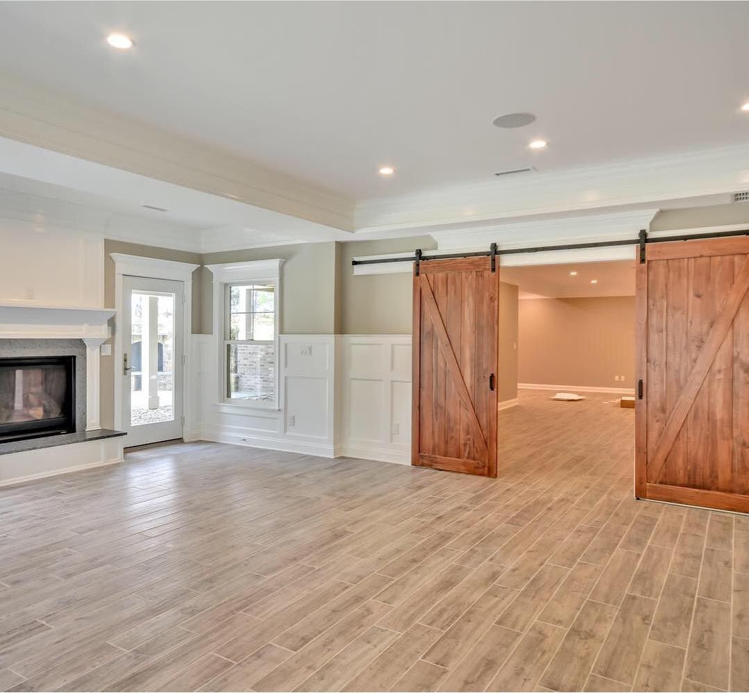 A living room with sliding barn doors and a fireplace.