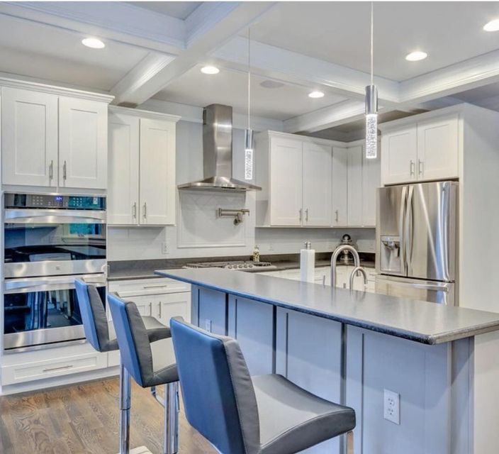 A kitchen with white cabinets and stainless steel appliances