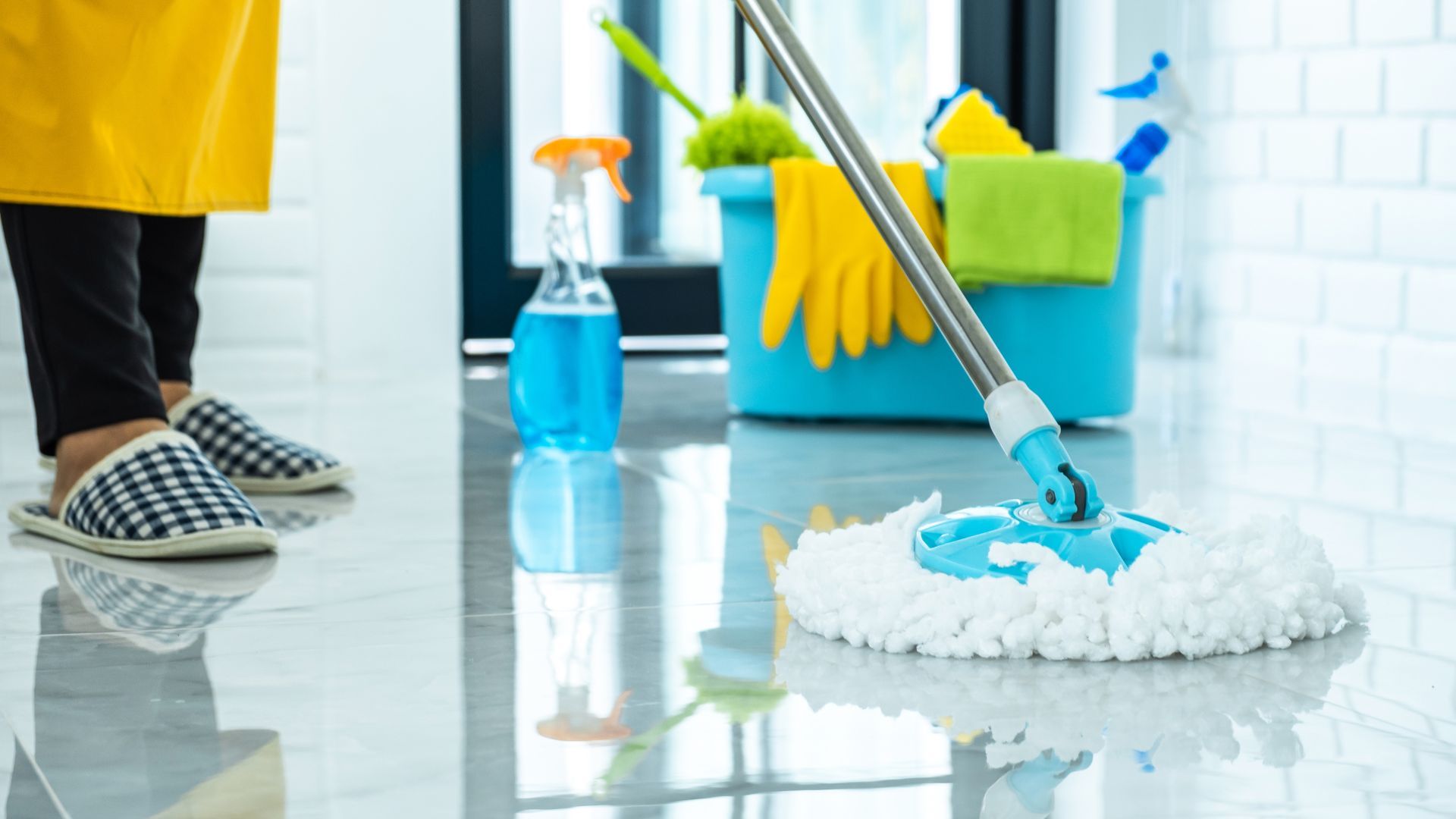 A woman is cleaning the floor with a mop.