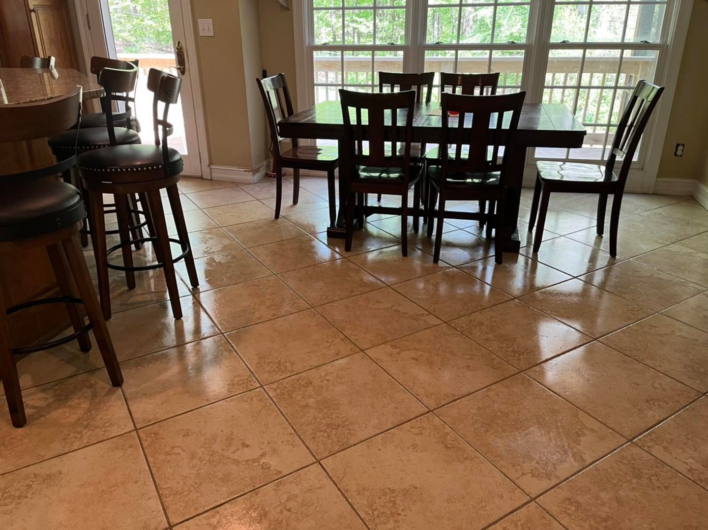 A dining room with a table and chairs and a tiled floor.