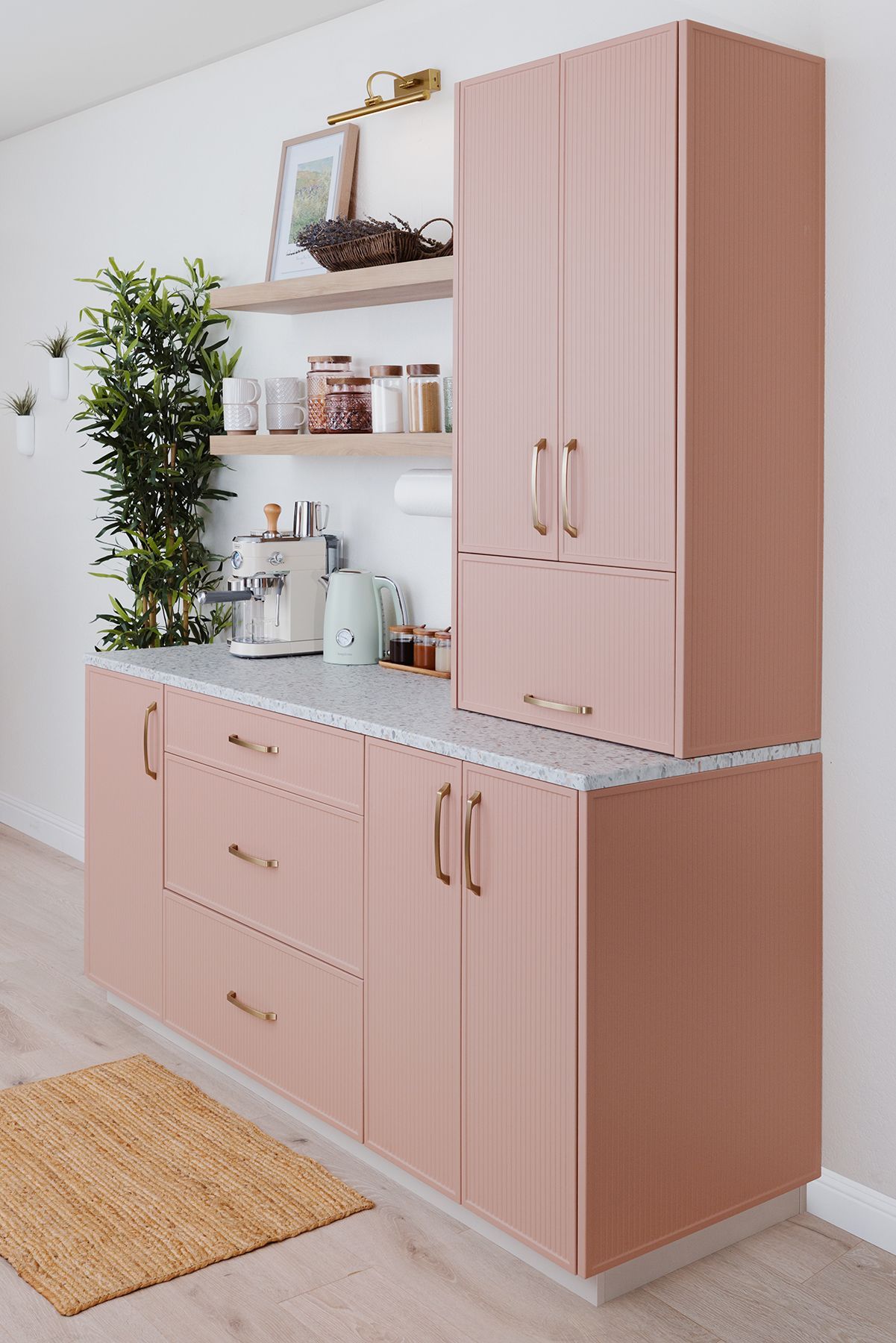Pink kitchen cabinets with countertop, shelving, and appliances. A tall cabinet is stacked on top of the lower cabinets.