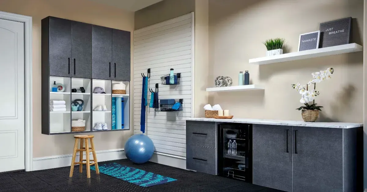 Home gym with dark gray cabinets, white shelves, and workout equipment on a black mat.