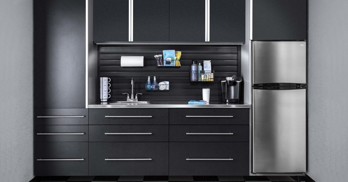 A black garage kitchenette with stainless steel appliances, cabinets, and storage accessories.