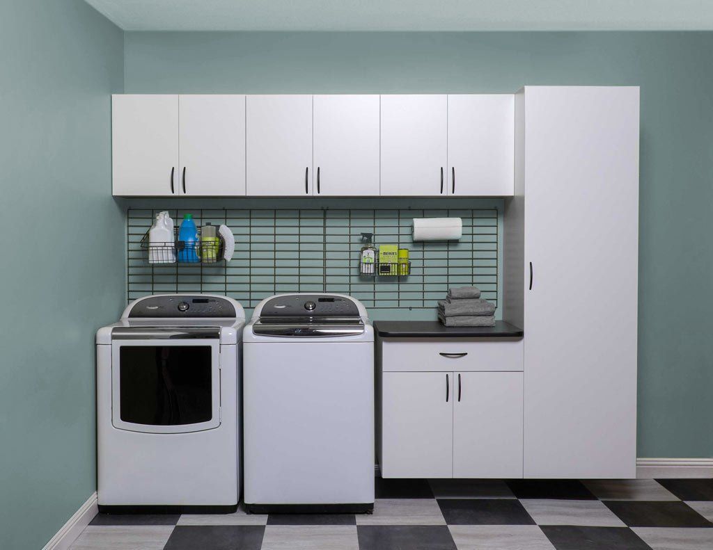 Laundry room with white cabinets, appliances, and checkered floor.