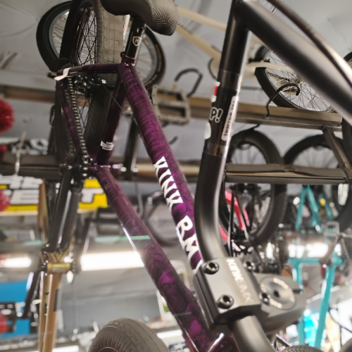 A man is working on a bicycle in a garage.