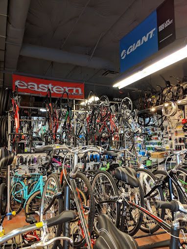 A bicycle store filled with lots of bicycles and a sign that says eastern.
