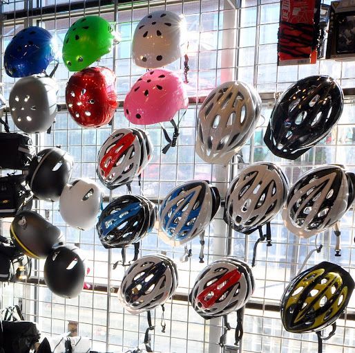 A bunch of different colored helmets hanging on a wall